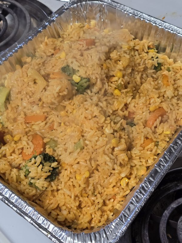 Foil pan full of Caribbean rice with mixed vegetables